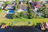 Neighborhood aerial. Pools and docks shown are on neighboring properties and are not included with this rental. Inland canal with fixed bridges and no