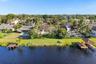 Neighborhood aerial. Pools and docks shown are on neighboring properties and are not included with this rental. Inland canal with fixed bridges and no