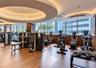 Fitness center featuring wood-finish flooring, floor-to-ceiling windows, recessed circular ceiling details, and integrated ambient lighting
