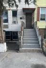 Multi-level exterior featuring horizontal siding, a concrete staircase with metal handrails, and a covered entryway