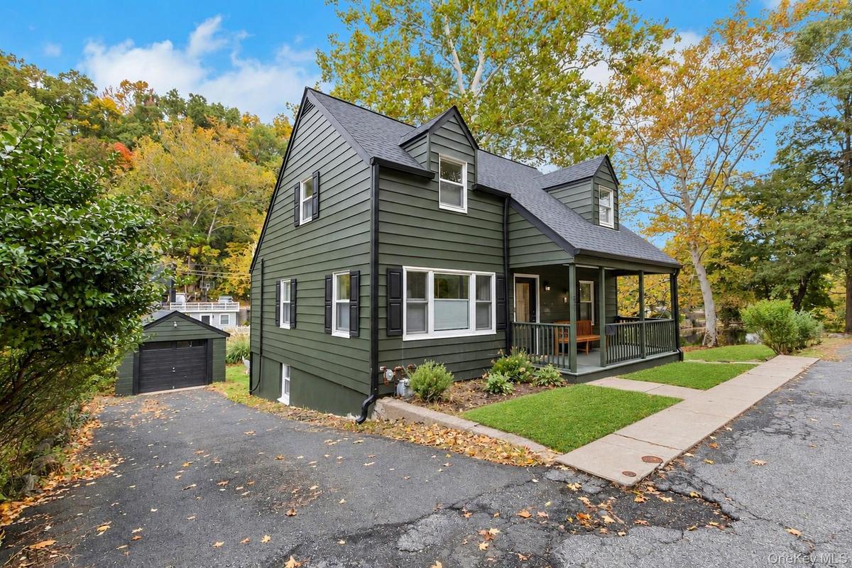 View of front of home featuring covered porch and a shingled roof and 1 car garage