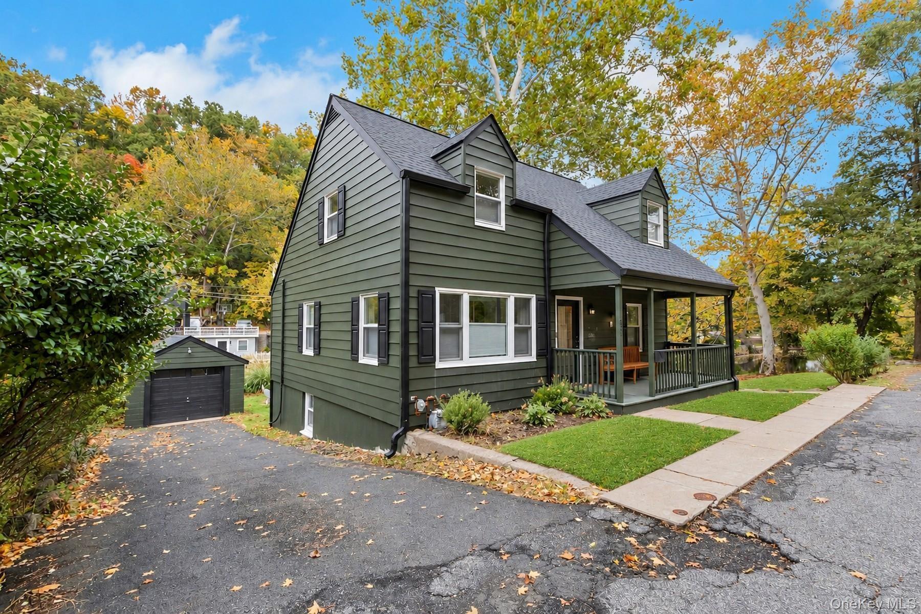 View of front of home featuring covered porch and a shingled roof and 1 car garage