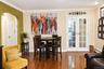 Wood-finish flooring, architectural arched opening, and glass-paned double French doors with white casing