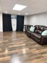 Wood-finish flooring, recessed lighting, and a drop ceiling with a central recessed light panel