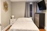 Room featuring wood-finish flooring, a window with horizontal blinds, and neutral wall paint