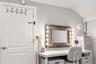 Vertical plank wall paneling and a dedicated vanity station featuring an integrated, wood-frame mirror with perimeter lighting