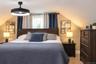Sloped ceiling with recessed window featuring a black matte finish ceiling fan with integrated LED lighting