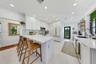 Kitchen featuring white cabinetry, quartz countertops, a striped backsplash, recessed lighting, and a built-in wine refrigerator