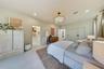 Bedroom featuring light-toned large-format tile flooring, recessed lighting, a modern multi-tiered chandelier, and floor-to-ceiling built-in cabinetry