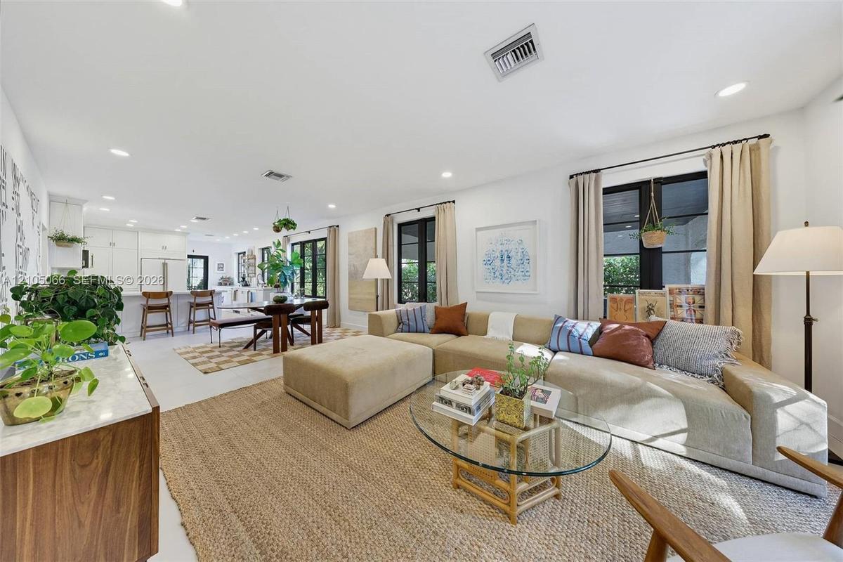 Open-concept interior featuring light-toned flooring, recessed lighting, and expansive windows with black frames