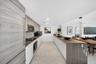 Kitchen featuring custom cabinetry with horizontal wood-grain finish, contrasting white lower cabinets, extended peninsula with wooden waterfall count