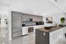 Contemporary kitchen featuring wood-finish cabinetry, a waterfall-edge kitchen island, integrated refrigerator, stainless steel appliances, and polish