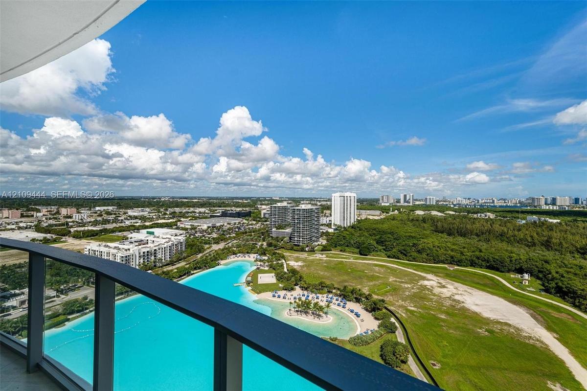 Private balcony with dark metal railings, panoramic cityscape, and coastal water feature