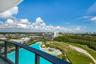 Private balcony with dark metal railings, panoramic cityscape, and coastal water feature