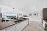 Kitchen featuring a central island with a wood-finish countertop, stainless steel undermount sink, high-arc faucet, white cabinetry with horizontal ha