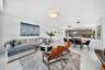 Open floor plan featuring polished stone-finish flooring, custom horizontal-grain cabinetry, quartz countertops, minimalist recessed lighting, and a m