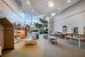Floor-to-ceiling windows, sculptural pendant lighting, recessed cove ceiling, built-in shelving niches, and neutral carpeted flooring