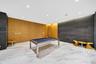 Interior space featuring large-format stone floor tiles, natural wood-finish wall paneling, charcoal-toned stone feature walls, and recessed ceiling l