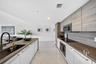 Kitchen featuring flat-panel cabinetry with wood-grain finish, polished stone-finish flooring, integrated appliances, and wood-finish countertops