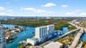 High-rise residential building featuring a swimming pool, tennis court, and immediate proximity to waterfront areas
