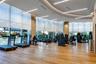 Fitness center featuring floor-to-ceiling windows, wood-finish flooring, curved recessed ceiling architecture, and linear pendant lighting