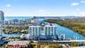 Aerial perspective of a high-rise residential building situated along a waterway, featuring coastal surroundings, expansive water access, and proximit