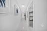 Hallway featuring polished tile flooring, recessed LED lighting, and a storage closet with built-in wooden shelving