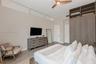 Floor-to-ceiling built-in wooden cabinetry, clerestory windows, wood-finish flooring, and a modern three-blade ceiling fan with integrated lighting