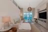 Living area featuring high ceilings with transom windows, full-height sliding glass doors, built-in media cabinetry, and wood-finish flooring