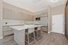 Kitchen featuring wood-finish cabinetry, stone-surface center island, stainless steel built-in appliances, and wood-finish flooring