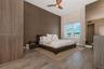 High-ceiling room featuring wood-finish flooring, a full-height decorative wood-paneled wall, a modern three-blade ceiling fan, and a floor-to-ceiling
