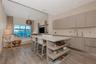 Open-concept kitchen featuring wood-finish cabinetry, a central island with integrated shelving, quartz countertops, wood-finish flooring, and recesse