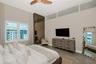 High ceilings featuring clerestory windows, bronze-toned mirrored wall paneling, and wood-finish flooring