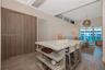 Central island with integrated shelving and solid surface countertop, wood-finish flooring, floor-to-ceiling wood-finish sliding doors, and clerestory