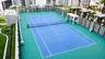 Rooftop multi-use athletic court featuring a synthetic surface, integrated basketball hoop, tennis net, and surrounding perimeter fencing with shade s