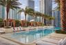 Swimming pool featuring stone-clad planters, integrated arched architectural accents, and palm tree landscaping