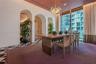 Architectural arched entryways, floor-to-ceiling windows with full-height drapery, geometric pattern tile flooring, and a multi-globe glass pendant li