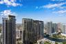 High-rise urban landscape featuring reflective glass facades, private balconies, and a canal waterway