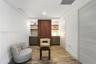 Custom built-in cabinetry with flat-panel doors, vertical slat wood accent feature, integrated floating shelving, recessed ceiling lighting, and wood-