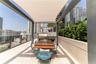 Rooftop terrace featuring a stone-topped outdoor kitchen, integrated gas grill, tension fabric shade structure, glass balcony railing, and stone tile 