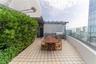 Rooftop terrace featuring patterned tile flooring, a built-in outdoor kitchen with stone countertop, stainless steel grill, pergola structure, and gla