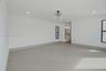 Minimalist interior featuring large-format tile flooring, recessed lighting, a modern drum-style chandelier, and expansive sliding glass doors framed 