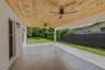 Neutral-toned flooring, multi-light chandelier, recessed ceiling lighting, and expansive glass sliding doors with black frames