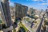 High-rise perspective featuring an outdoor swimming pool, landscaped green roofs, glass-facade architecture, and water frontage