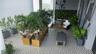 Covered terrace featuring geometric patterned floor tiling, built-in vertical green wall, and large-scale architectural planters
