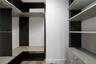 Custom built-in storage system featuring dark wood-tone cabinetry, multiple open shelving tiers, integrated drawer units, and light-toned horizontal s