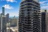 High-rise glass and concrete exterior featuring wraparound balconies, floor-to-ceiling windows, and a curved architectural design