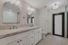 Interior space featuring light-toned tile flooring, neutral walls, a tiered crystal-style flush mount ceiling fixture, and recessed lighting