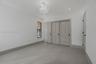 Neutral-toned tile flooring, recessed lighting, ornate central pendant fixture, black-framed windows, and built-in closet with panel doors