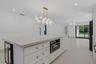 Kitchen featuring shaker-style cabinetry, stone countertops with matching backsplash, a large center island, built-in beverage refrigerator, and reces